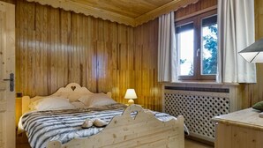 Une pièce en bois avec un lit, une fenêtre et une lampe.