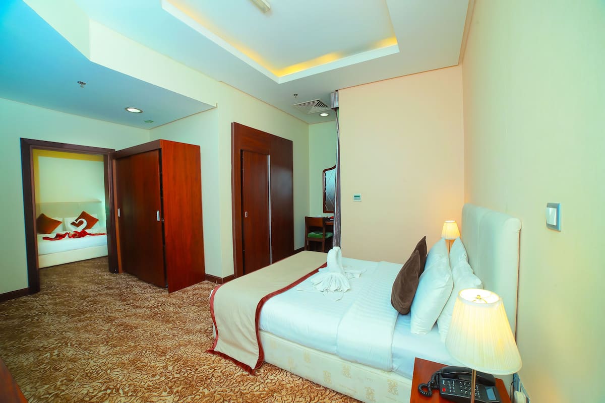 Una habitación de hotel con cama, lámpara de noche y teléfono.