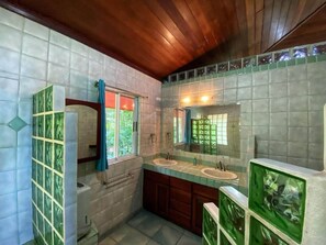 Ein Badezimmer mit zwei Waschbecken, einem Spiegel und einem Fenster.