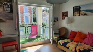 Ein Zimmer mit Bett, Sessel, Tisch und Blick ins Freie.