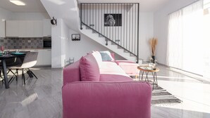 Un espacio moderno para vivir con una escalera, comedor y cocina.