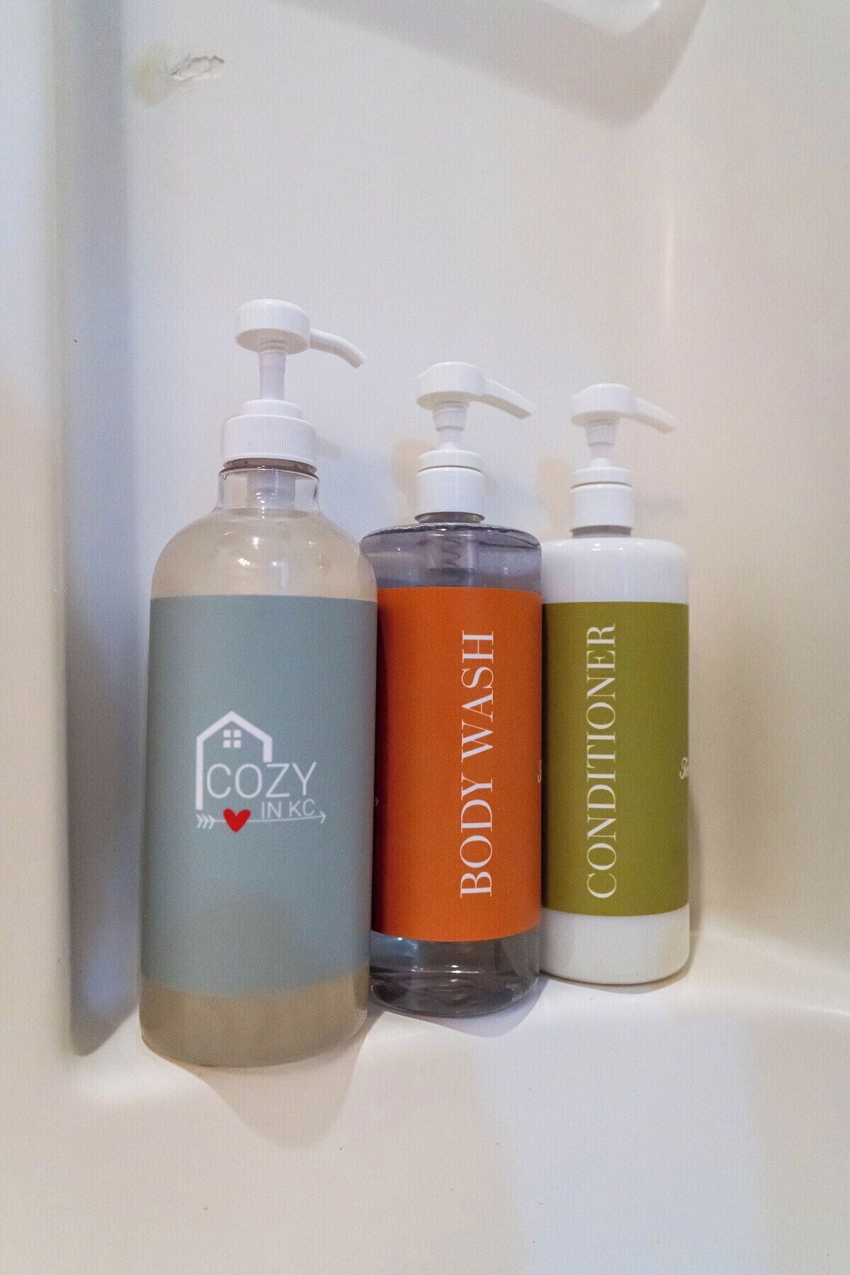 Three bottles of liquid soap on a white shelf.