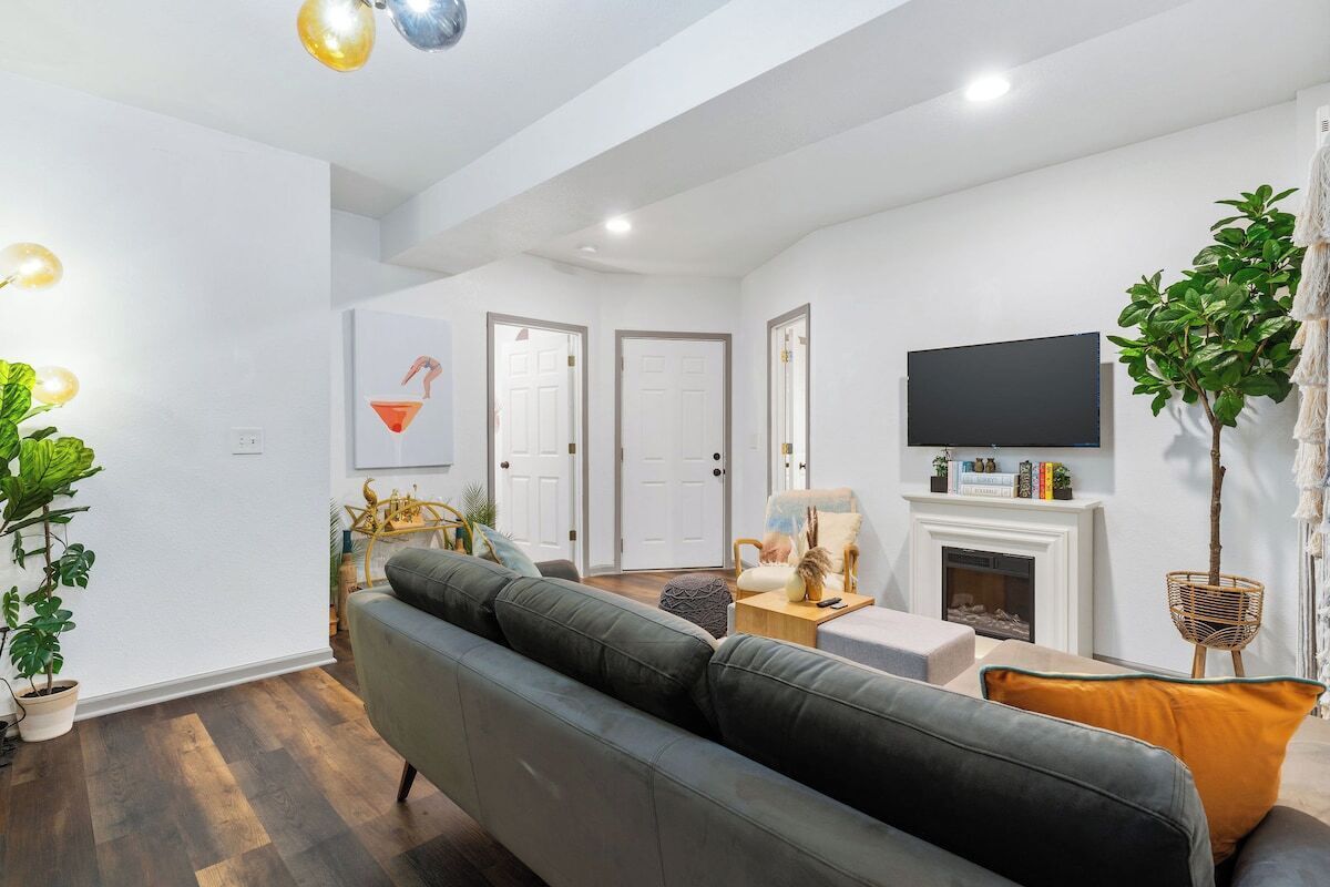 A modern living room with a sofa, a television, and a fireplace.