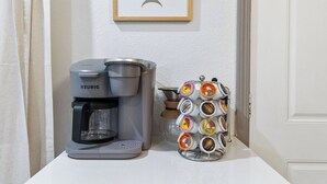 A Keurig coffee maker and a coffee pod holder on a white countertop.