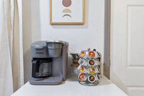 Una cafetera Keurig y un soporte para cápsulas de café sobre una encimera blanca.