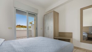 A bedroom with a bed, a wardrobe, a bathroom mirror, and a sliding door to a balcony. - 2833 Residence Solaris - Bilo Standard PT by Barbarhouse (Melendugno)
