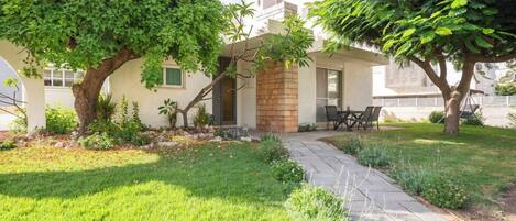 A house with a patio, a brick fireplace, and a lawn.