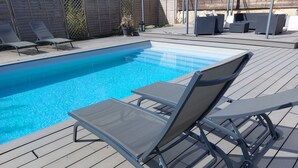 A swimming pool with lounge chairs and a wooden deck. - Le Paddock (La Drenne)