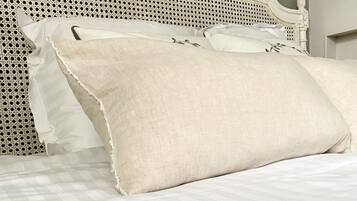 Una cama con cabecera blanca y colcha a cuadros.