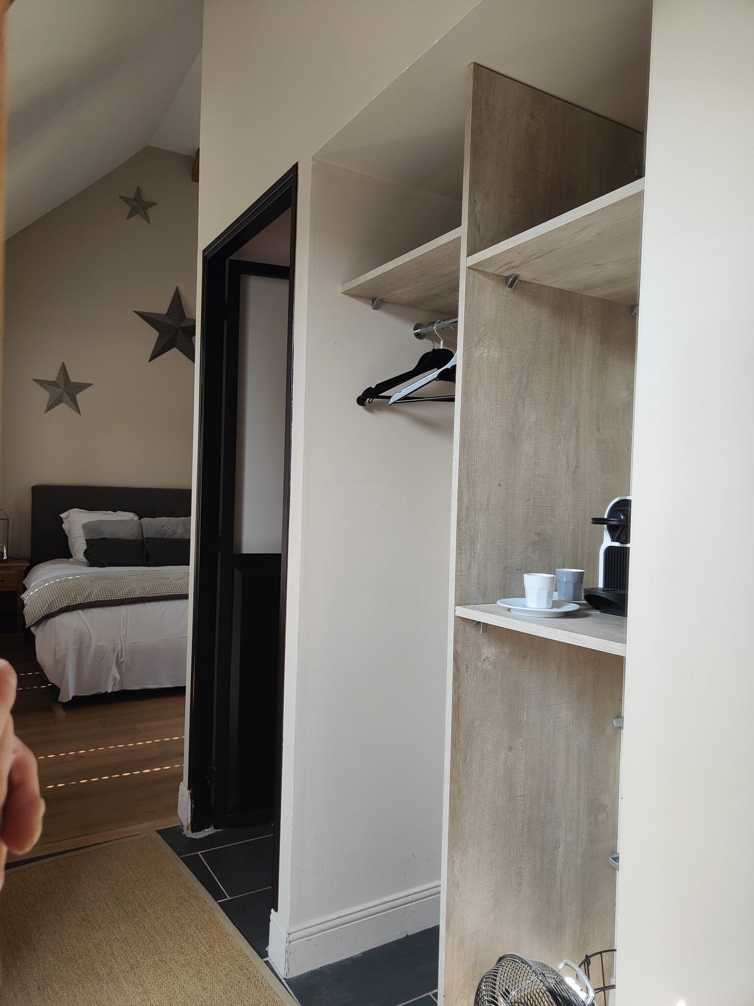 A bedroom with a bed, a nightstand, and a dresser. There are star decorations on the wall.