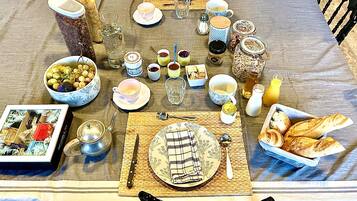 A breakfast table set with plates, cups, and various condiments.