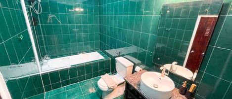 A bathroom with a bathtub, toilet, sink, and shower.