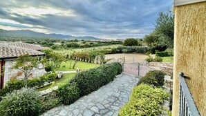 A stone pathway leading to a courtyard with a view of distant mountains and a cloudy sky. - House / Villa - Budoni (Tanaunella (Budoni))