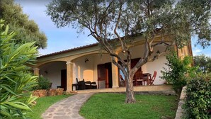 A house with a stone pathway leading to a covered patio area with outdoor furniture. - House / Villa - Budoni (Tanaunella (Budoni))