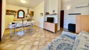 A compact living space with a dining area, kitchenette, and a sofa. - House / Villa - Budoni (Tanaunella (Budoni))