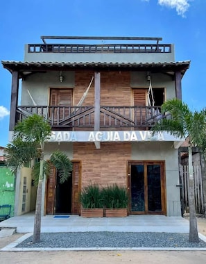 A two-story building with a balcony and a sign that reads 'SADA AGUA DA VIDA.' - Pousada Aguia da Vila (Jijoca de Jericoacoara)