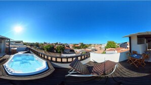 A rooftop terrace with a hot tub, outdoor seating, and a view of the surrounding neighborhood. - Pousada Aguia da Vila (Jijoca de Jericoacoara)