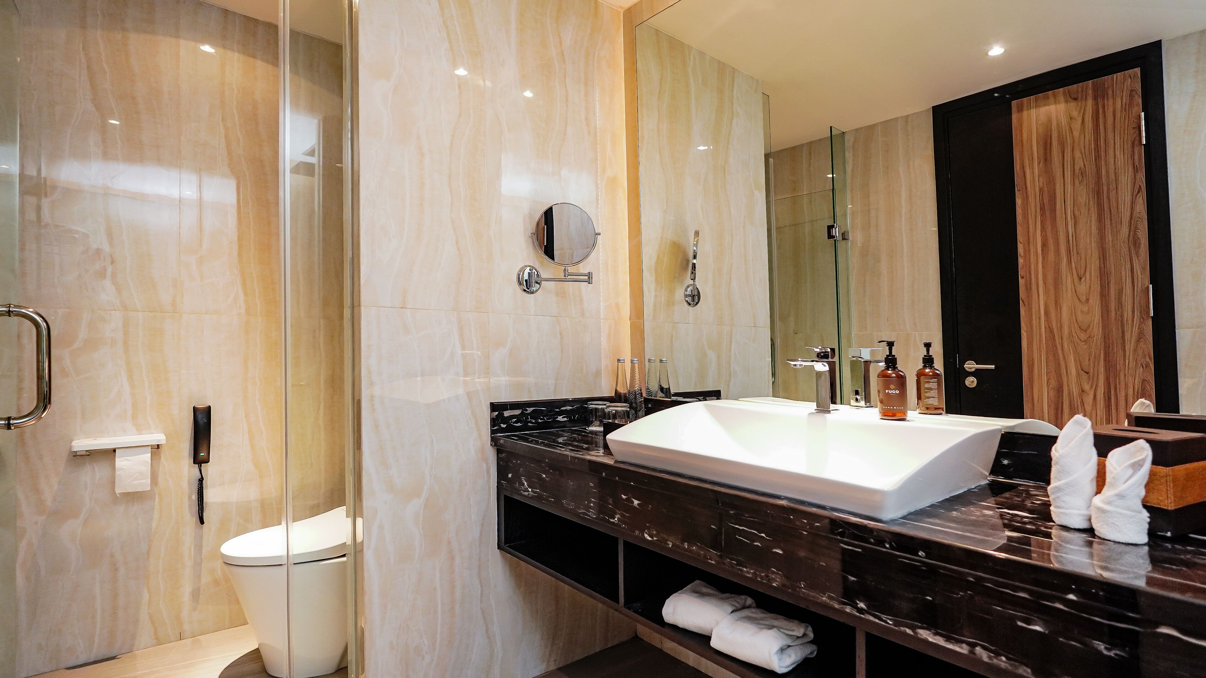 Un baño moderno con un lavamanos grande, espejo y cabina de ducha con mampara de vidrio.
