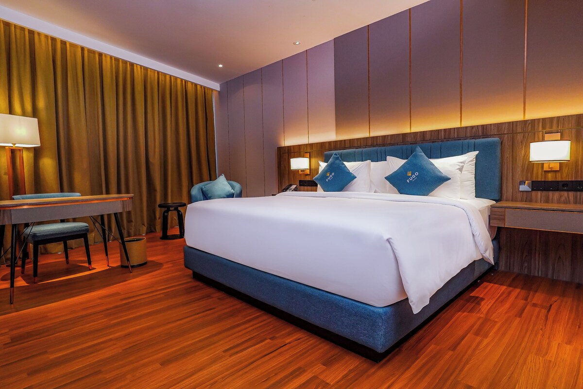 Habitación de hotel con una cama grande, un escritorio y una silla.