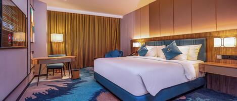 Una habitación de hotel con una cama grande, un escritorio, una silla y un televisor.