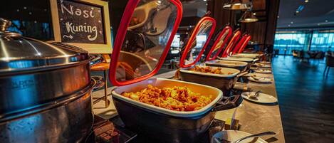 A buffet setup with multiple serving stations, each with a covered dish and a spoon.