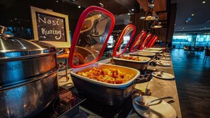 A buffet setup with multiple serving stations, each with a covered dish and a spoon. - FUGO Hotel Samarinda (Bigmall)  (Samarinda)
