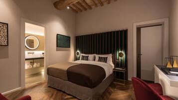 A modern hotel room with a large bed, a desk, and a red chair.