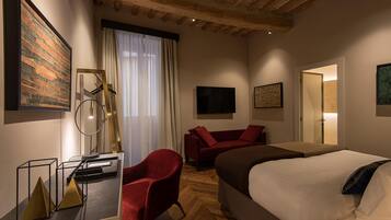 Een moderne hotelkamer met een groot bed, een rode fauteuil, een flatscreen televisie en een houten plafond.