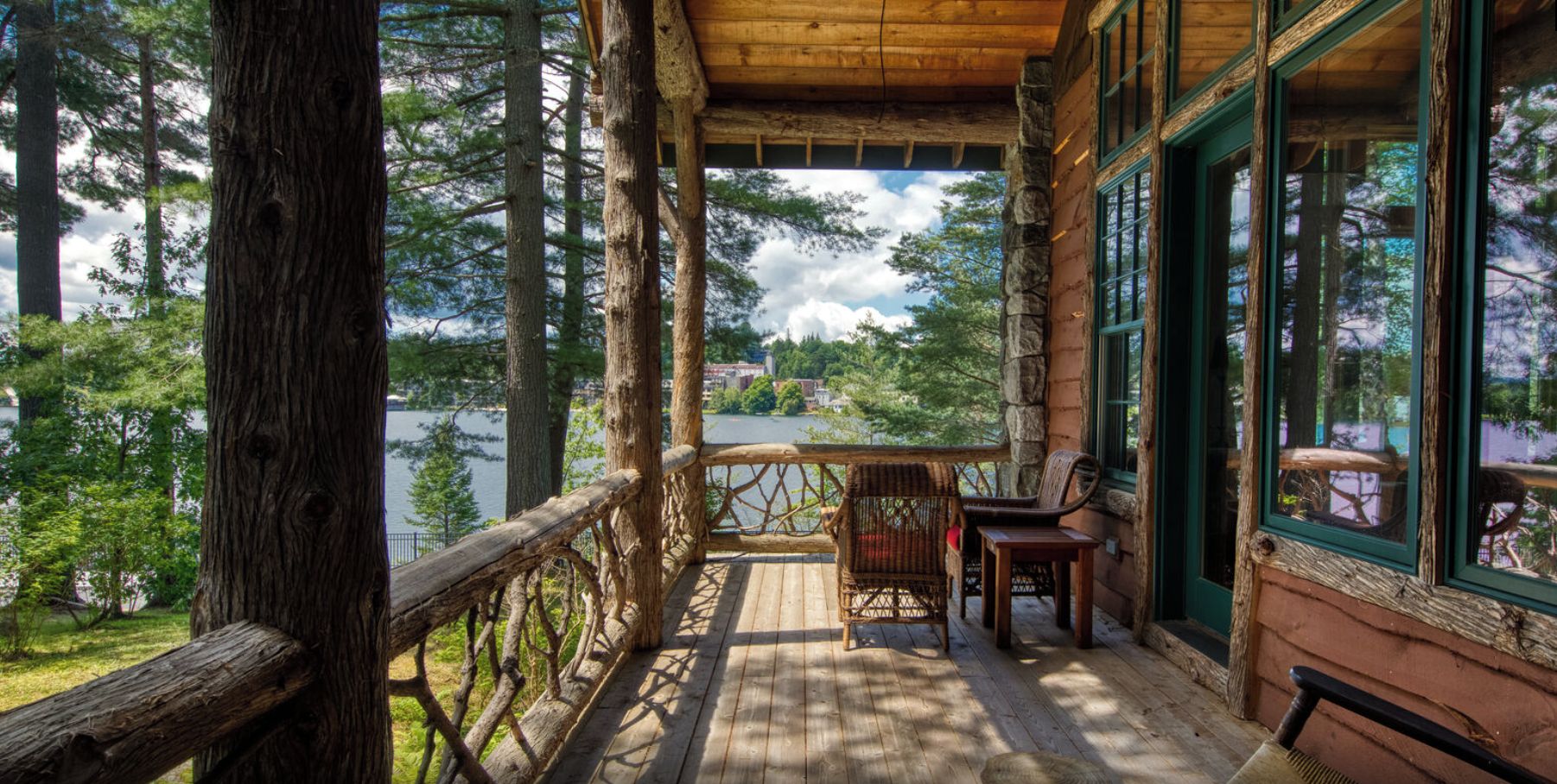 Una terraza de madera con vistas a un lago y árboles.