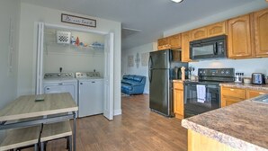 A kitchen with wooden cabinets, a stainless steel refrigerator, a microwave, and a stove. There is a laundry area with an old-fashioned washing machine and dryer. A sign above the door reads "Be our Guest." - Minutes to local attractions, interstates, and places of interest such as JCMC, ETSU, the the VA. (Johnson City)