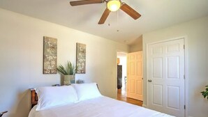 A bedroom with a bed, a ceiling fan, and two wall-mounted floral paintings. - Minutes to local attractions, interstates, and places of interest such as JCMC, ETSU, the the VA. (Johnson City)