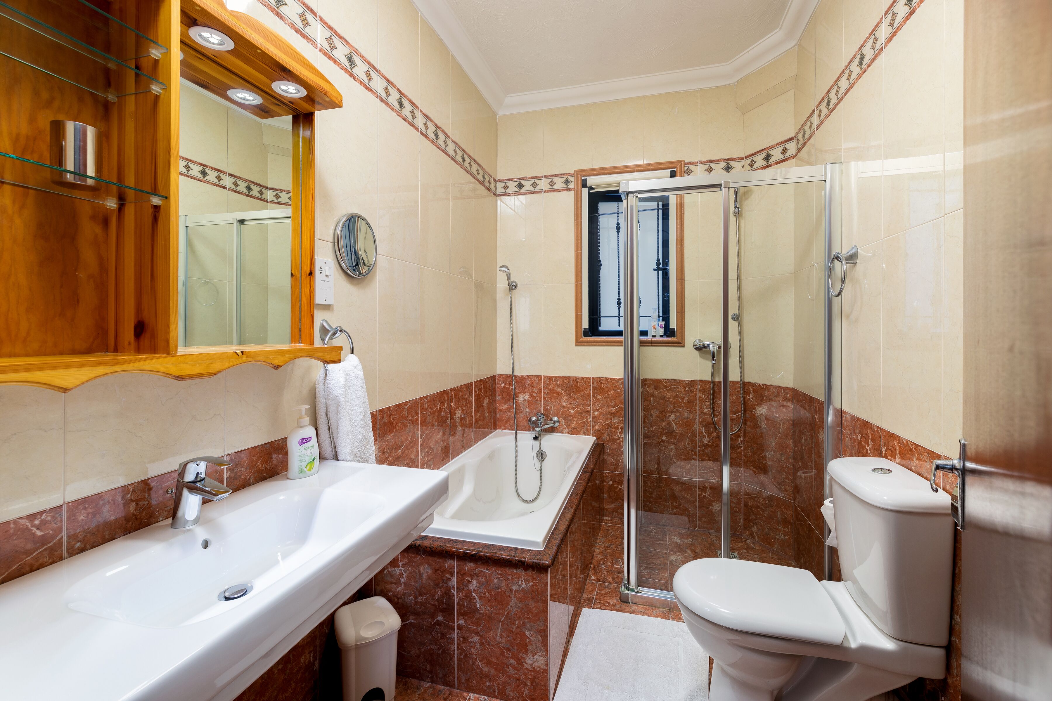 Une salle de bain équipée d’un lavabo, d’une baignoire, de toilettes et d’une douche à parois en verre.