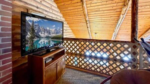 Un plafond en bois dans une pièce où se trouve un téléviseur posé sur un meuble en bois.