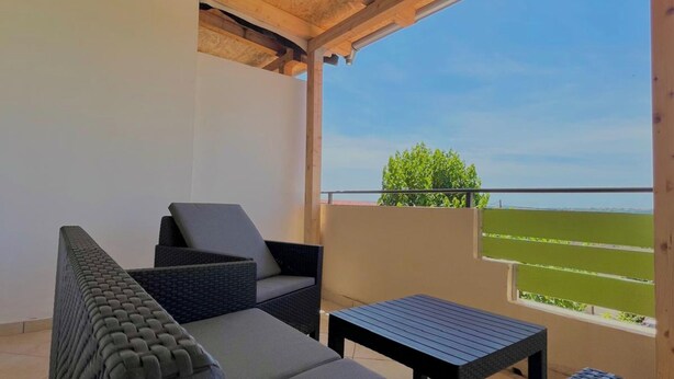 A covered outdoor seating area with a view of the sea. - Holiday Home Mary with Pool (Policnik)