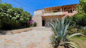 A two-story building with a stone facade, a balcony, and a stone-paved entrance. - Holiday Home Mary with Pool (Policnik)