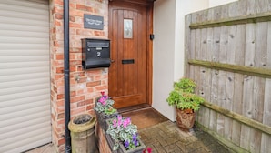 A wooden door with a mailbox and a sign reading "The Coach House". - The Coach House (Cheltenham)