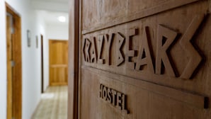 A wooden door with the words "CRAZYBEAR HOSTEL" carved into it. - Crazy Bears Hostel (Moalboal)