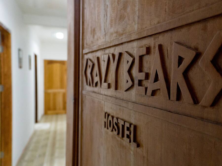 A wooden door with the words "CRAZYBEAR HOSTEL" carved into it.