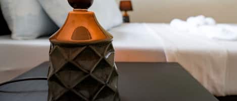 Moderni lamppu, jossa on geometrinen kuvio, hotellihuoneen yöpöydällä.