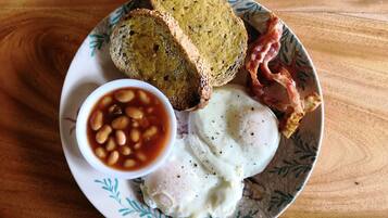 Une assiette avec un œuf dur, des haricots, des toasts et du bacon.