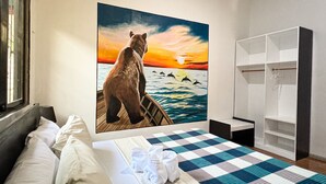 A hotel room with a bed, a painting of a bear on a dock, and a wardrobe. - Crazy Bears Hostel (Moalboal)