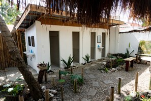 A courtyard with a white building, a wooden bench, and a small table.