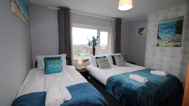 A hotel room with two beds, a window with a view, and a painting on the wall. - Chadwick House (Sheffield)