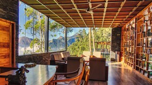 Un interior moderno con una mesa de madera, sillas y una estantería.