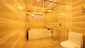 A modern bathroom with a glass-enclosed shower, a bathtub, and a toilet.