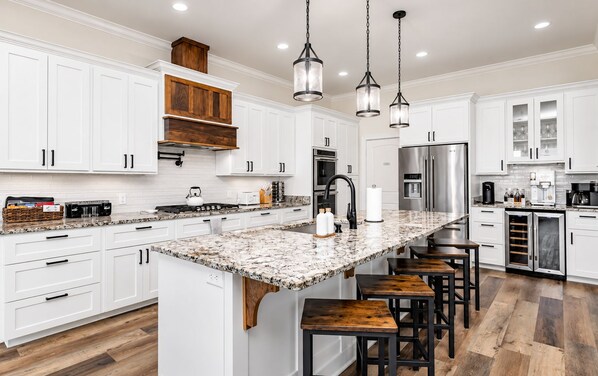 A modern kitchen with white cabinetry, a granite countertop, and stainless steel appliances.