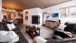 A modern living room with a fireplace, a television, and a cozy seating area. - Remodeled Eolus Ski in/Ski Out condo - Views - Deck (Durango)