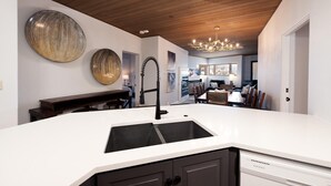 A modern kitchen with a white countertop, dark cabinets, and a wooden ceiling. - Remodeled Eolus Ski in/Ski Out condo - Views - Deck (Durango)