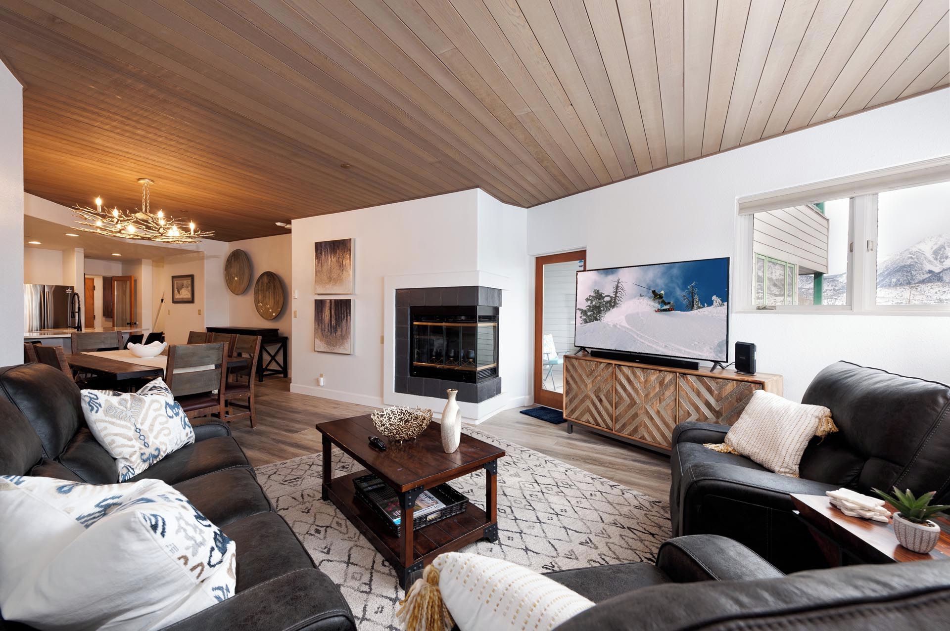 Una sala de estar moderna con chimenea, televisor y un área de descanso acogedora.