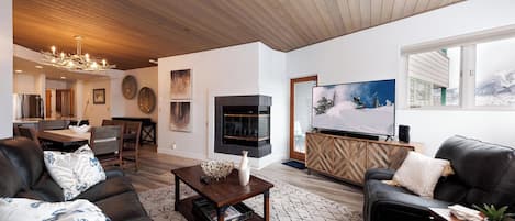 Una sala de estar moderna con chimenea, televisor y un área de descanso acogedora.